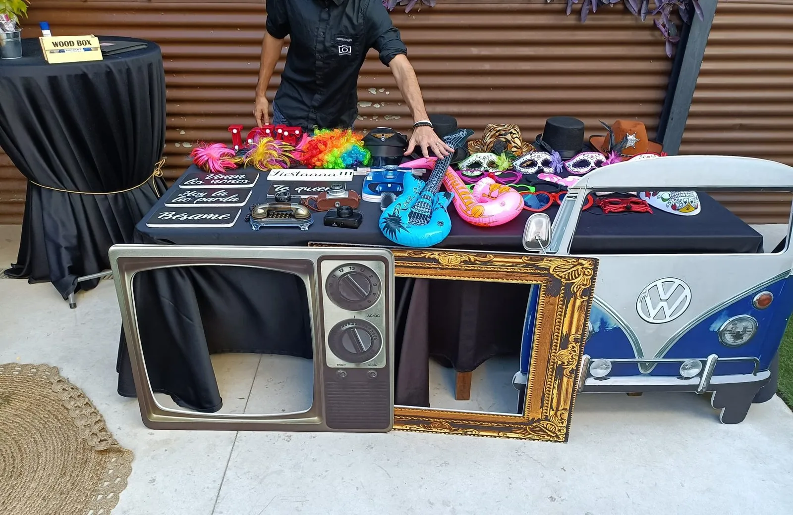 Mesa de atrezzo con pelucas, sombreros y carteles, el marco de televisión, el marco dorado y la furgoneta de cartón